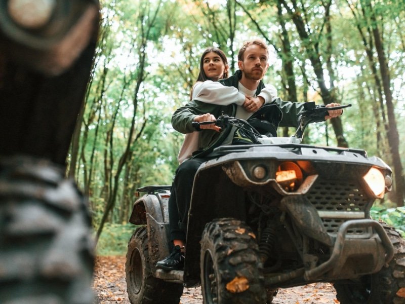 Couple faisant du quad dans une forêt de normandie